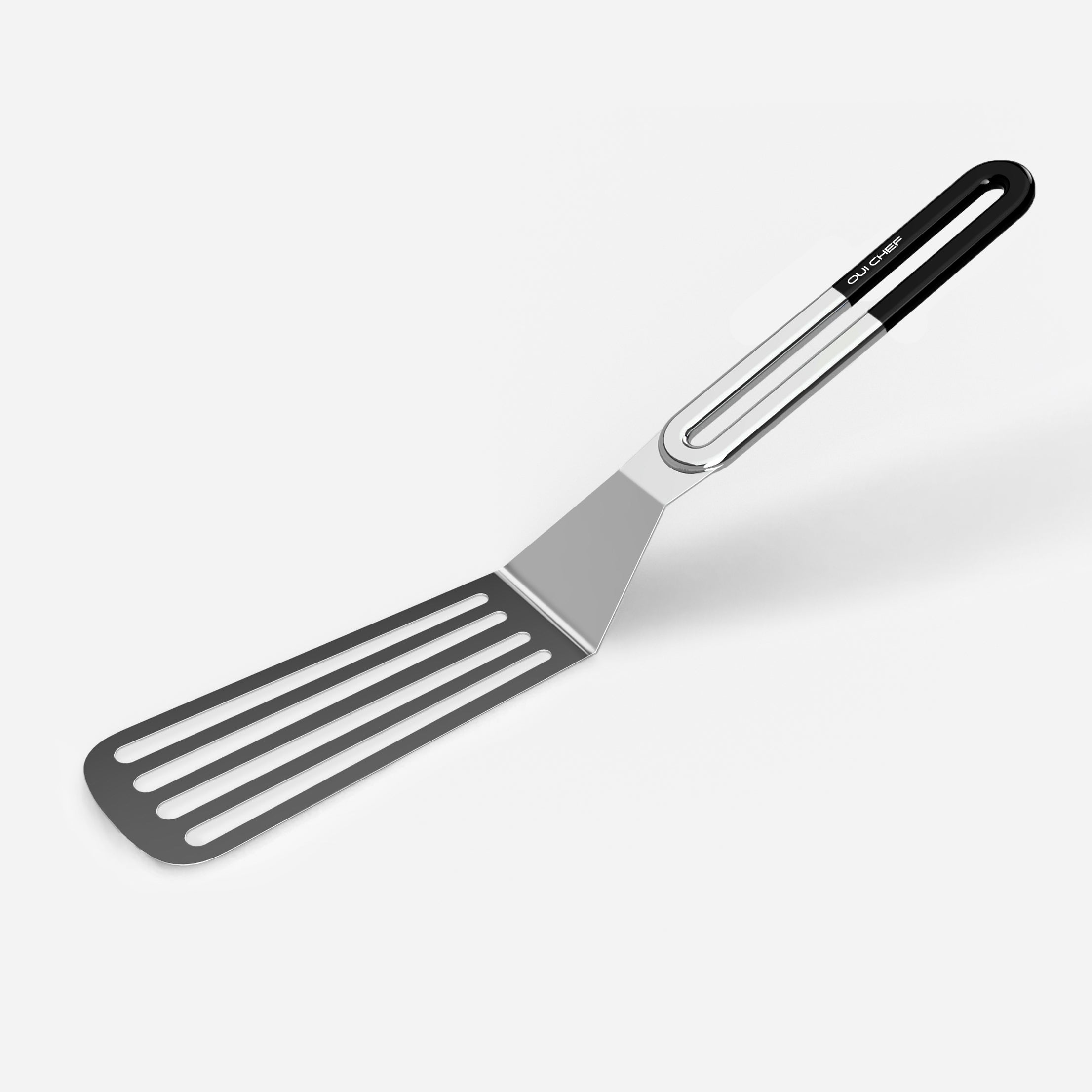 A stainless steel slotted spatula with a black coloured handle against a white background.