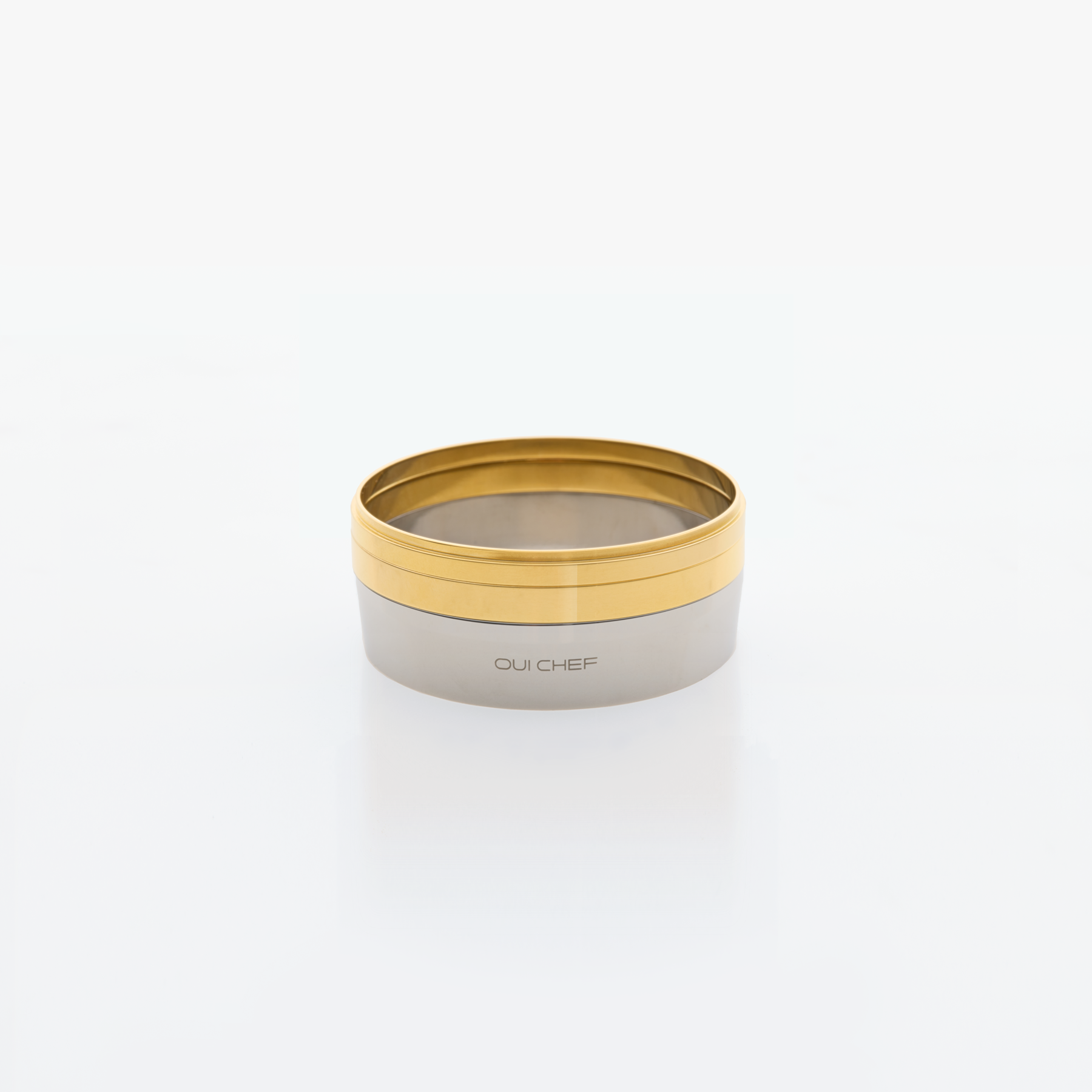 Ring moulds with two stackable gold rings sitting on top of the base against a white background.