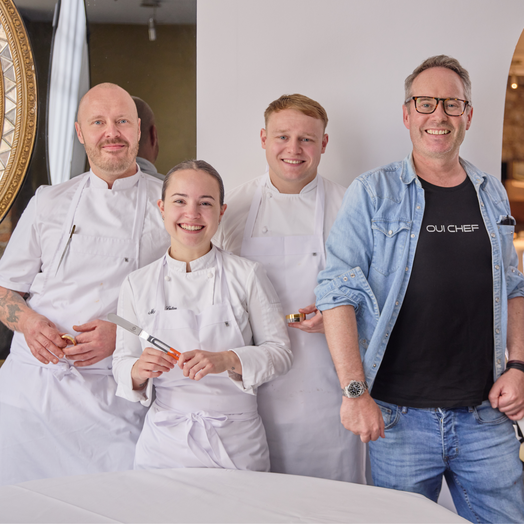 Three chefs and the owner of Oui Chef posing for a team photo.