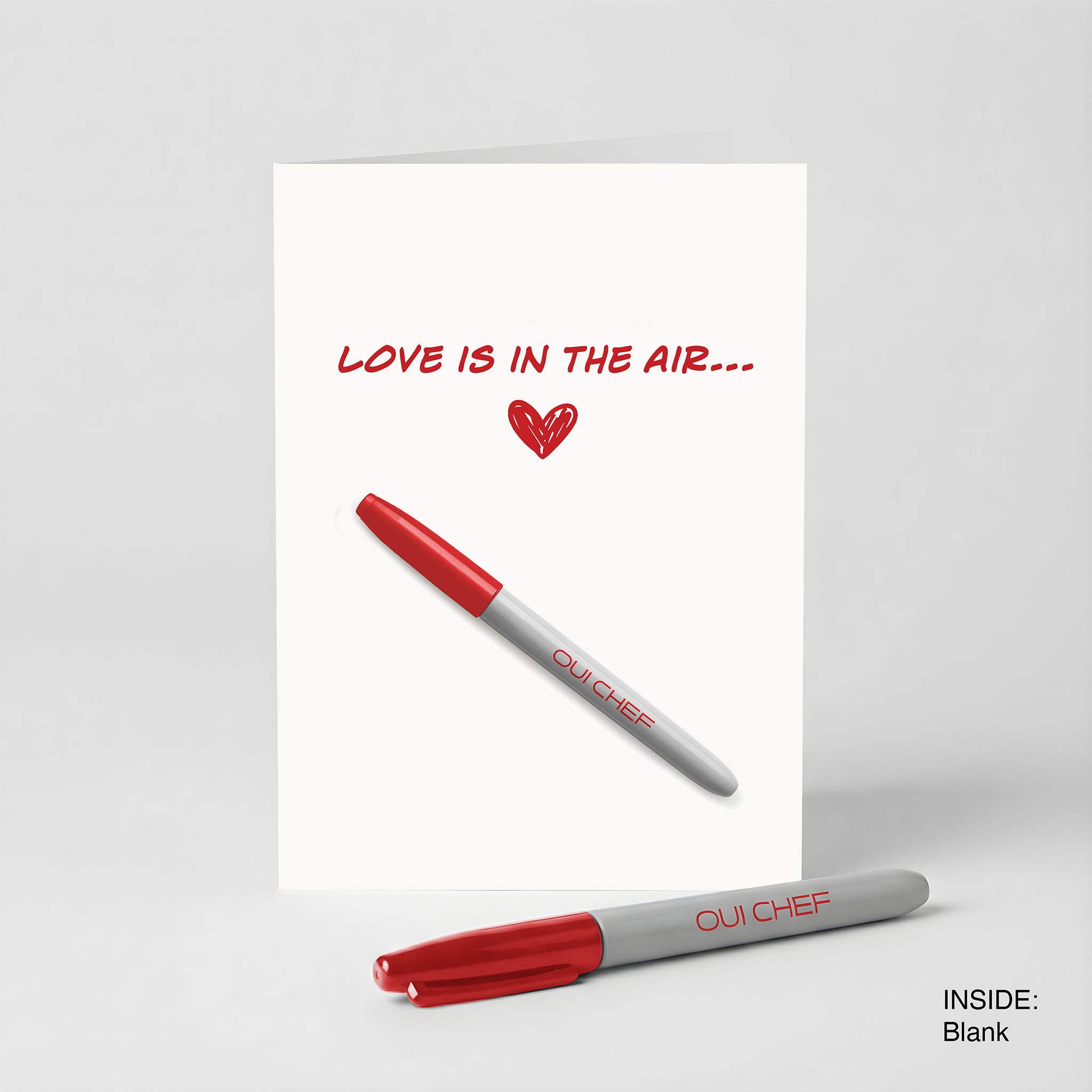 Valentines card with 'Love is in the Air' text and a red Sharpie on a white background.