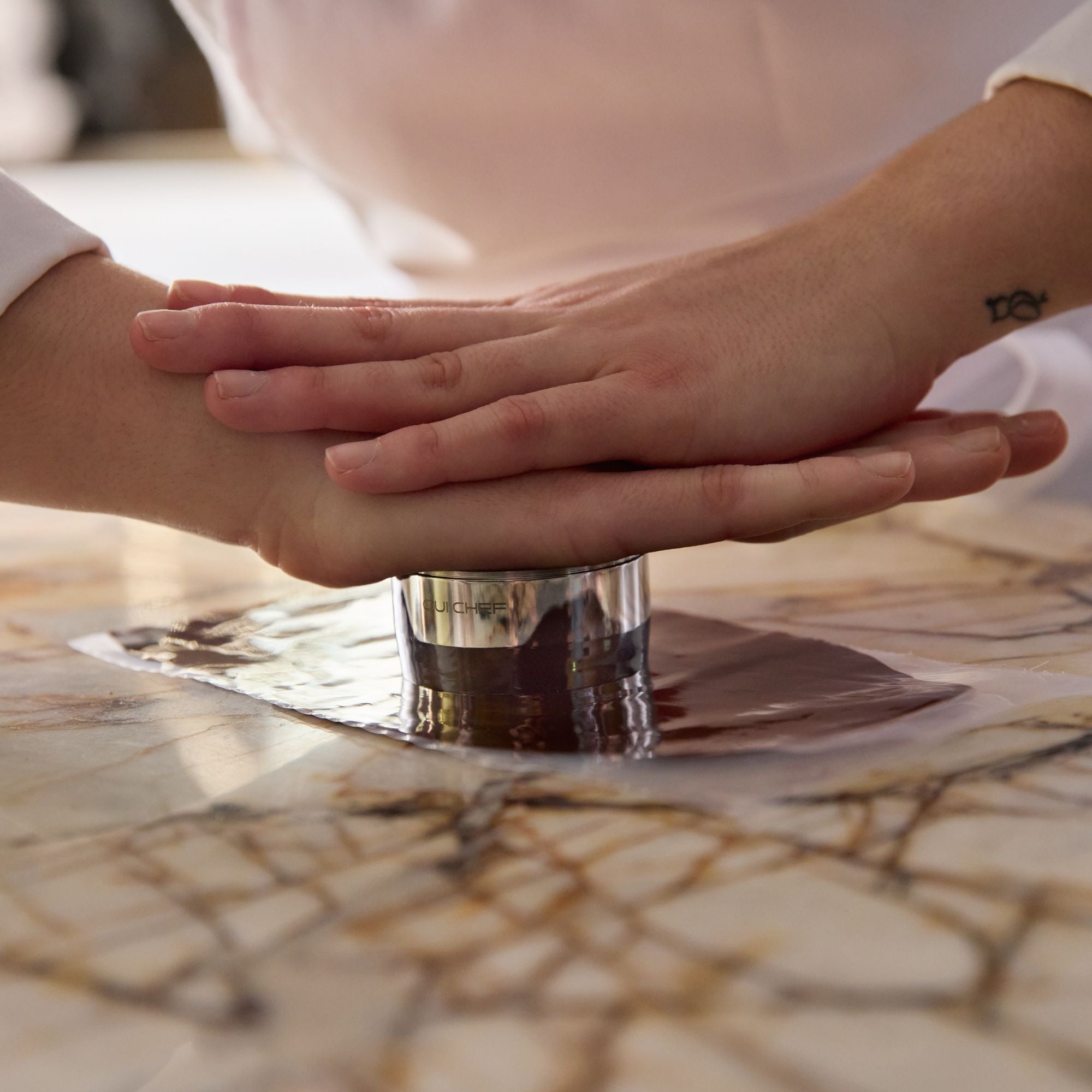Close-up of chef pressing down on the stackable ring mould to create outline with the sharpened base.
