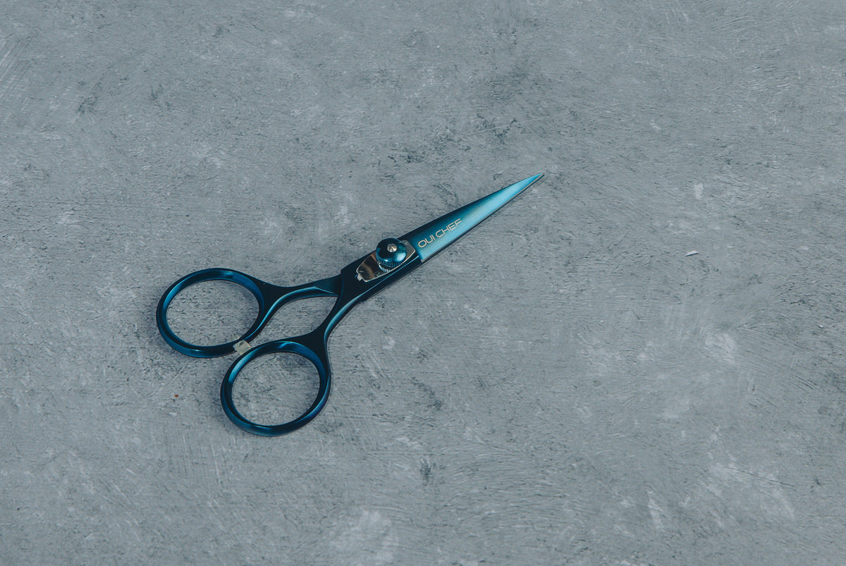 Blue SuperSharp Oui Chef scissors on grey surface