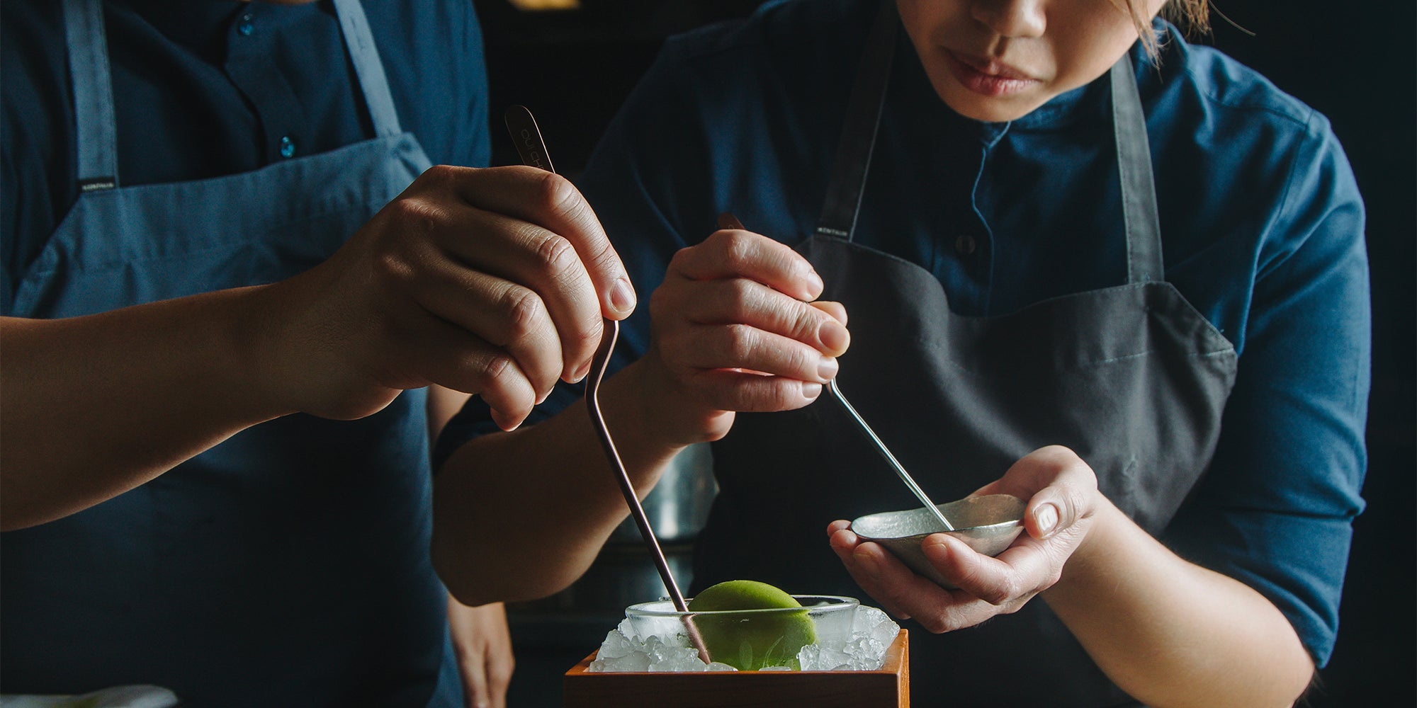 Two Chefs expertly plating a dish using Oui Chef offset tweezers